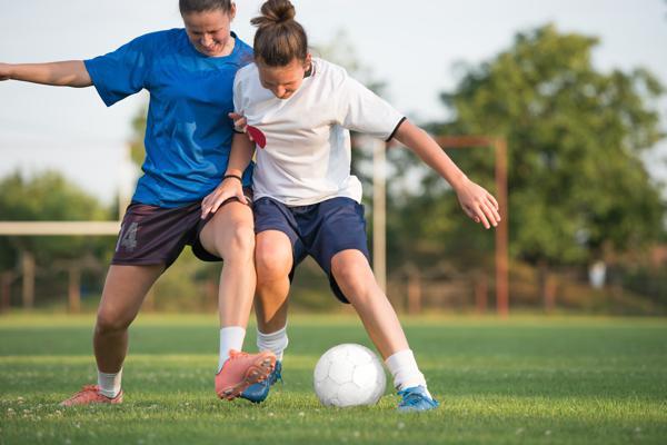 Girls competing for a soccer ball